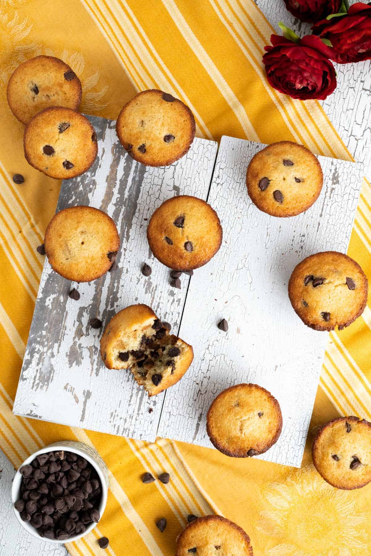 over the head shot of chocolate chip muffins spread over yellow table cloth. 