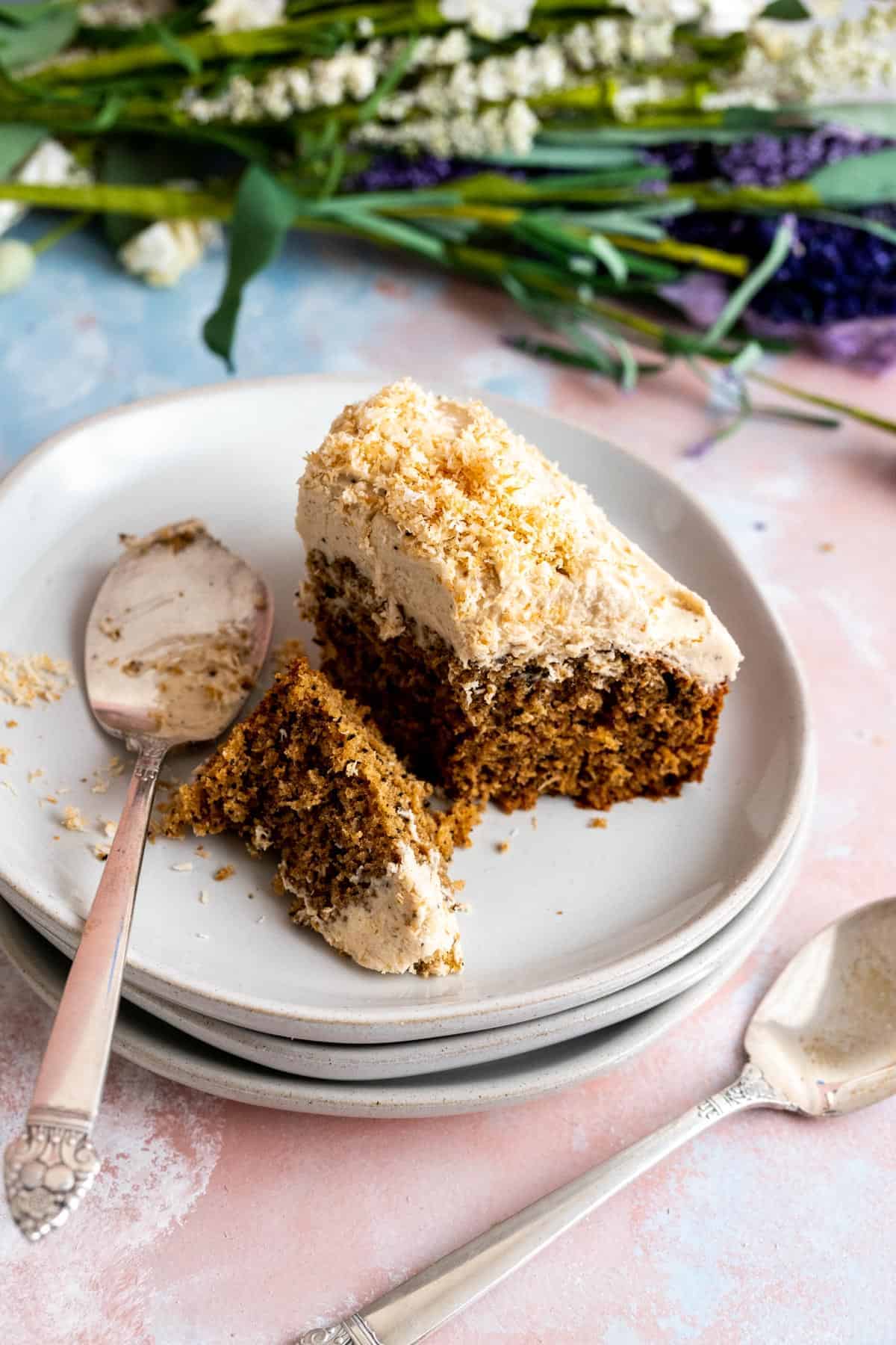 One slice of Coconut Coffee Cake on a white plate with silver spoon.