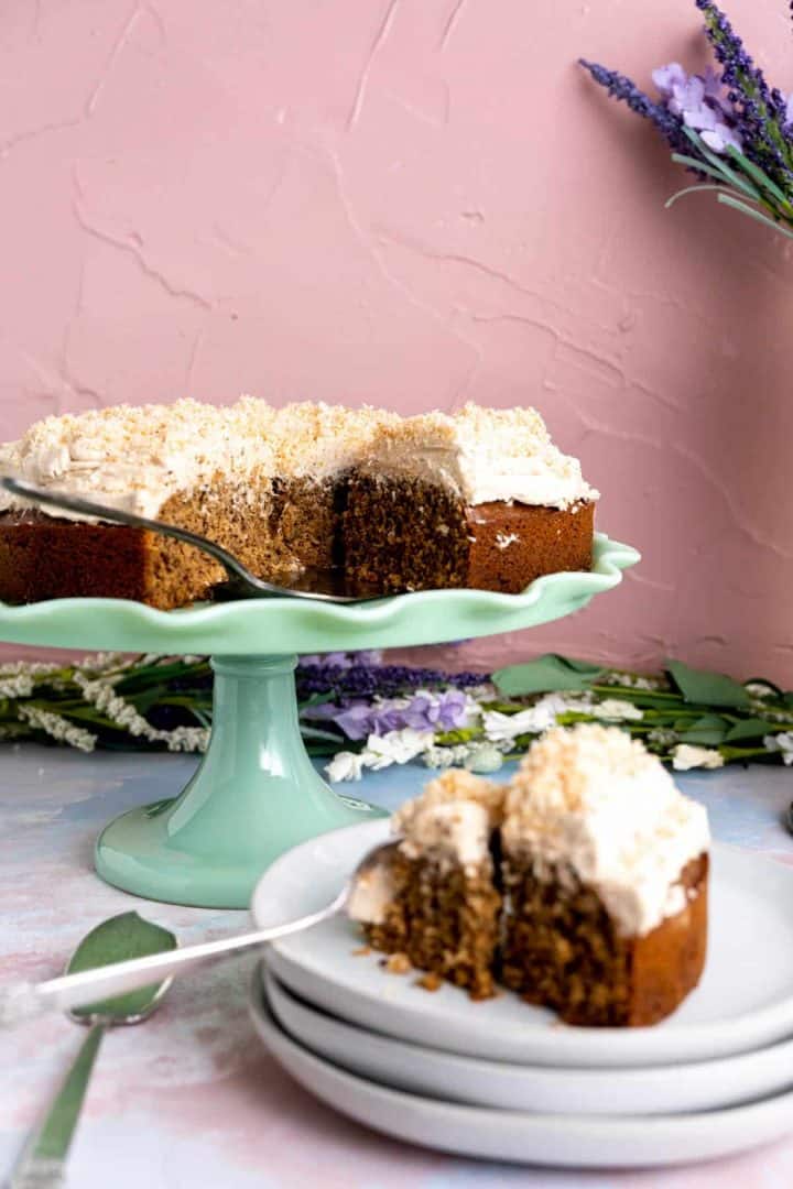 a slice of coconut coffee cake on a small white plate on the table.