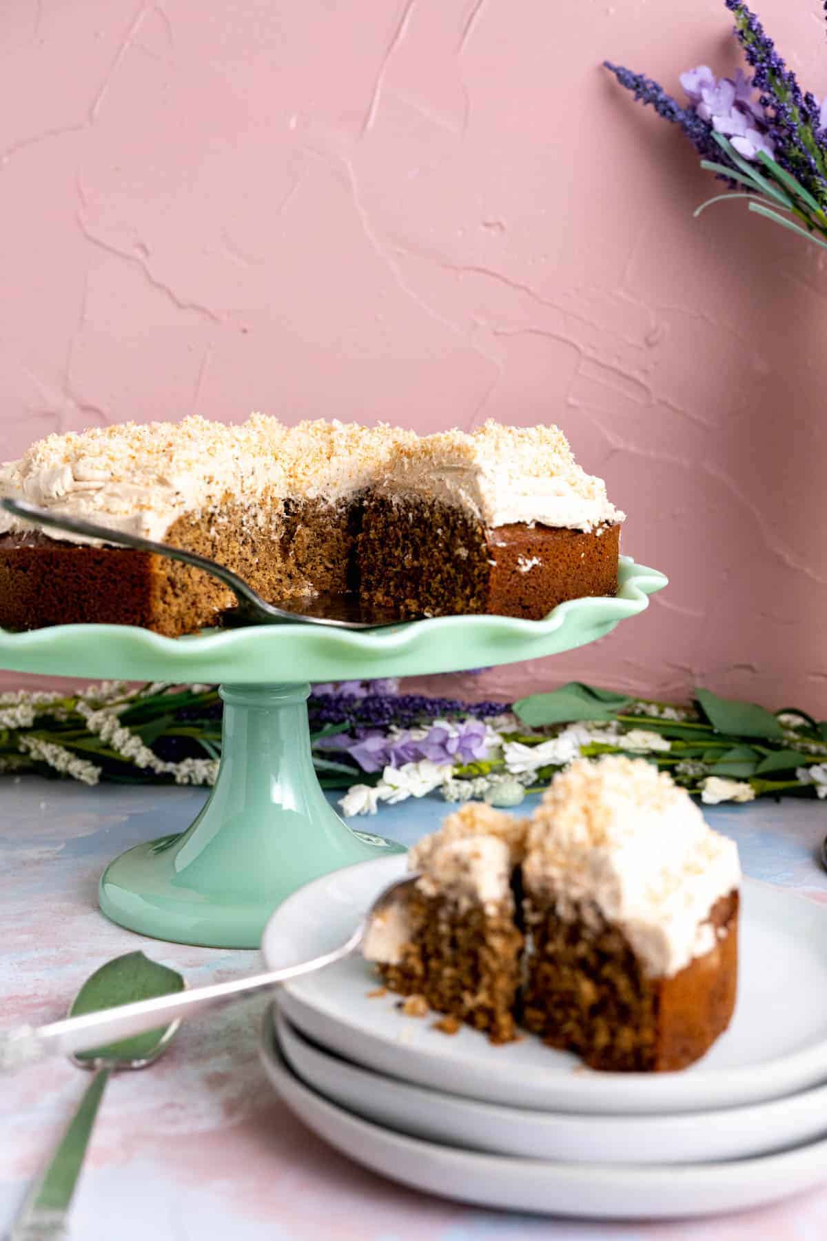 One slice of Coconut Coffee Cake on a small white plate on the table.