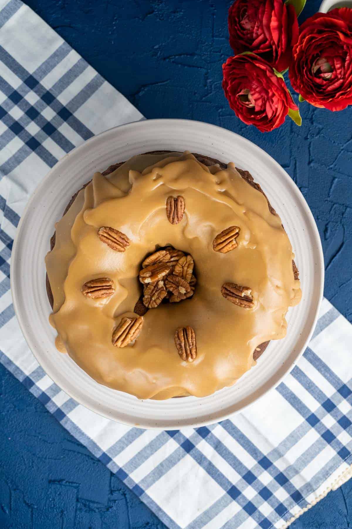 overhead shot of Bundt Cake in a cake plate sitting on blue and white table cloth.