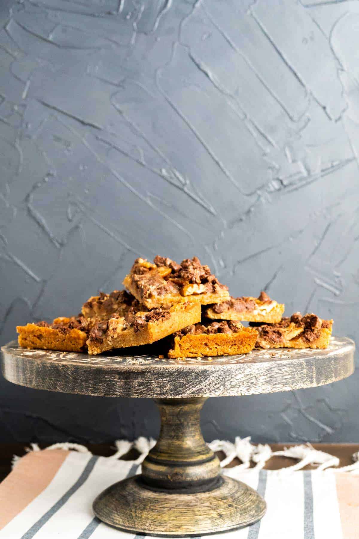 Turtle cookies sitting on the cake plate on a table.