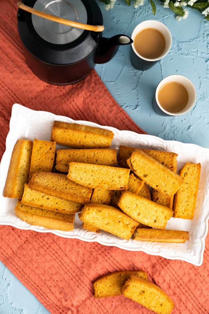 overhead shot of cake rusks in a white page with tea glasses on the side.