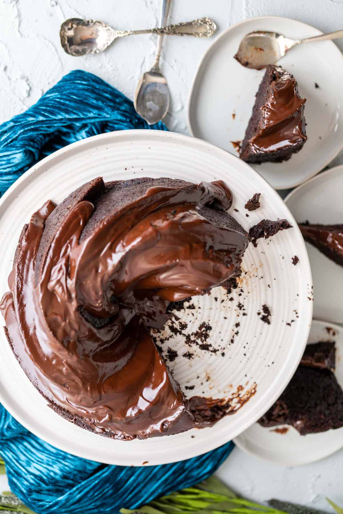 overhead shot of dark chocolate bundt cake on a white cake plate.