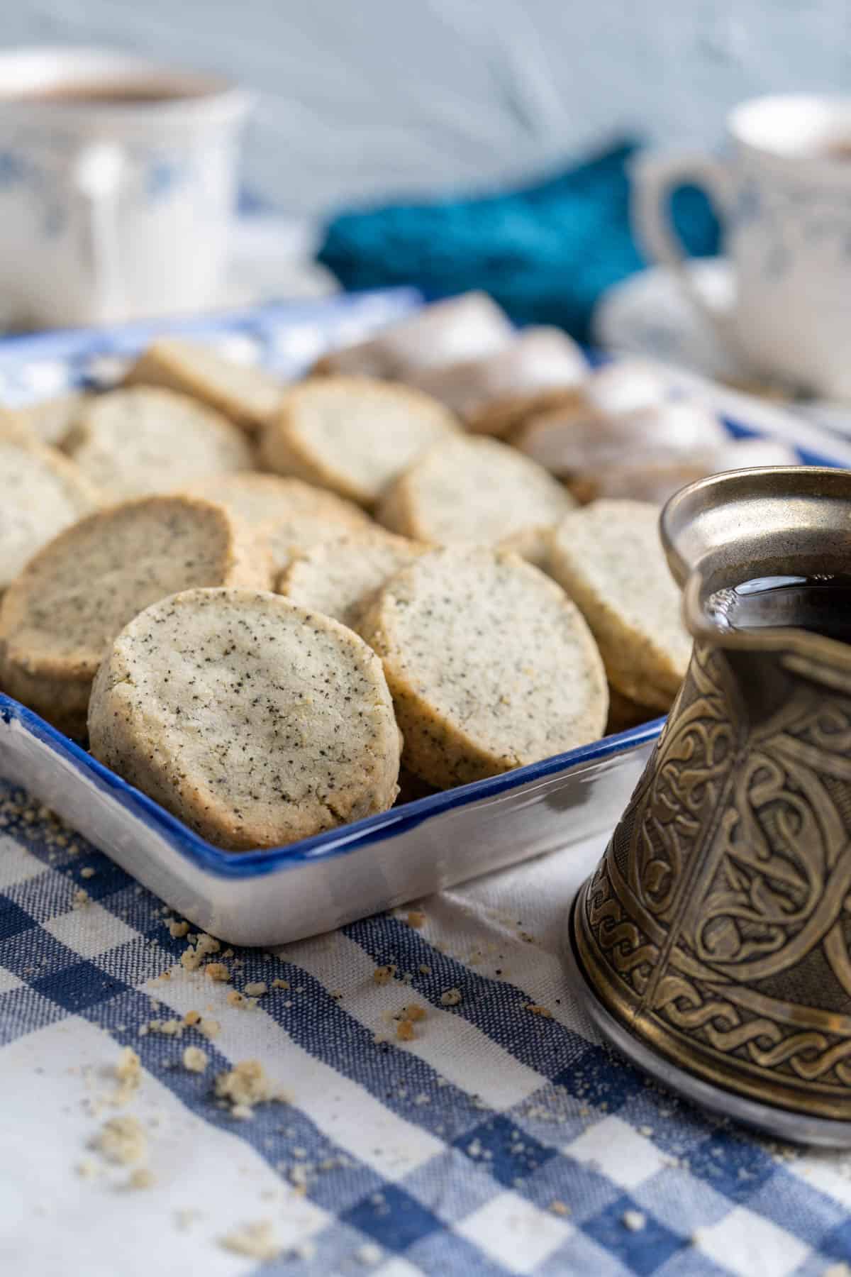 earl grey shortbread cookies placed in a decorative blue square plate with tea pot in the side.