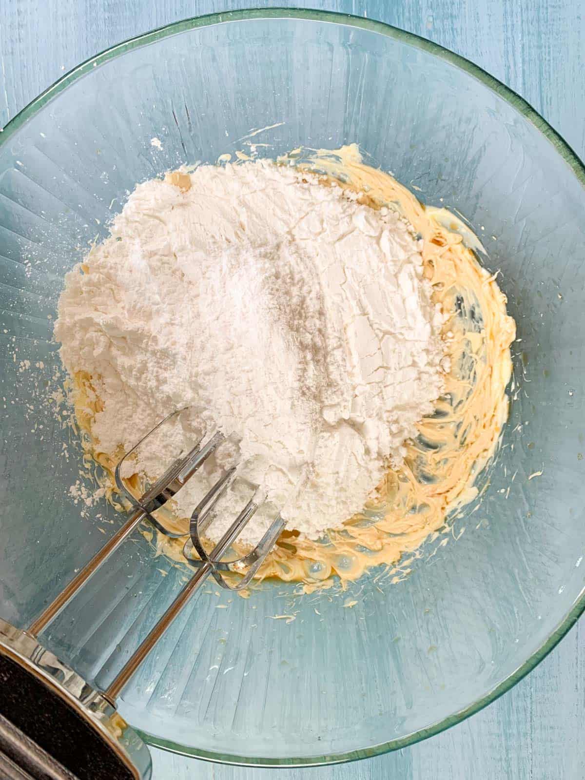 icing sugar added to the beaten butter in the bowl for buttercream frosting.