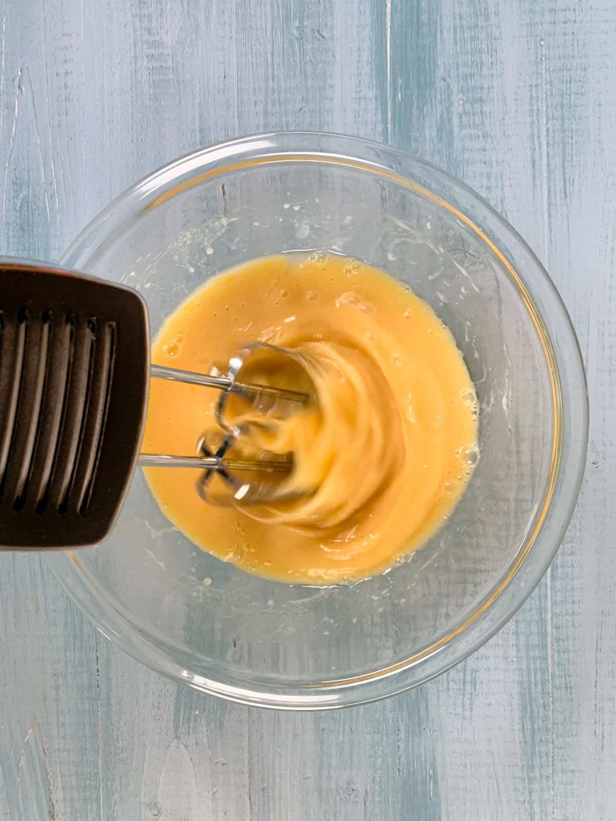 beating the wet ingredients for vanilla cupcakes with an egg beater.