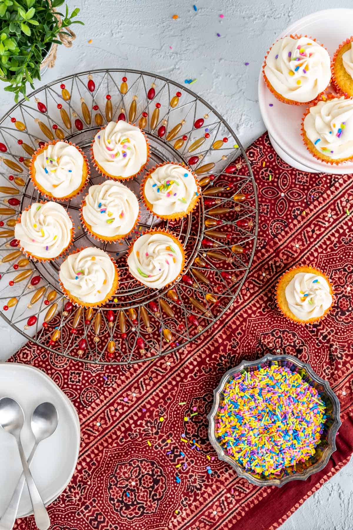 ten vanilla cupcakes with oil placed on the table over red table cloth.