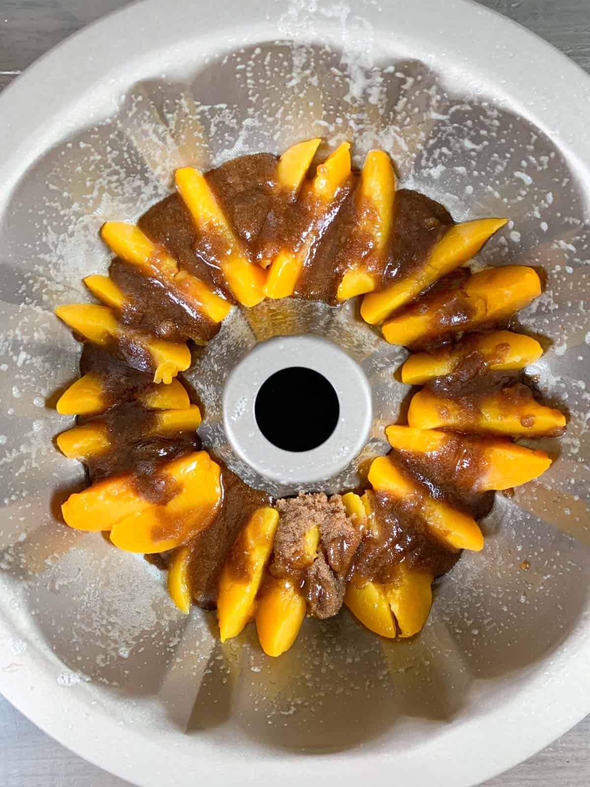 bundt cake pan with peaches and brown sugar mixture.