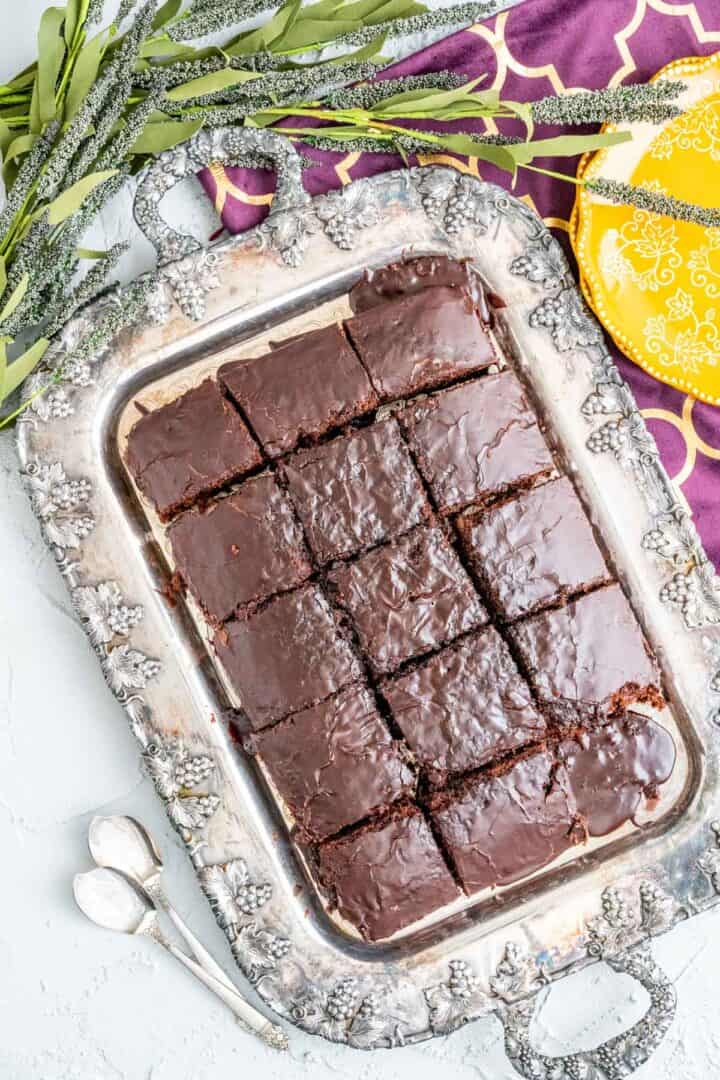 overhead shot of the coca cola cake in an antique silver tray with flowers around.