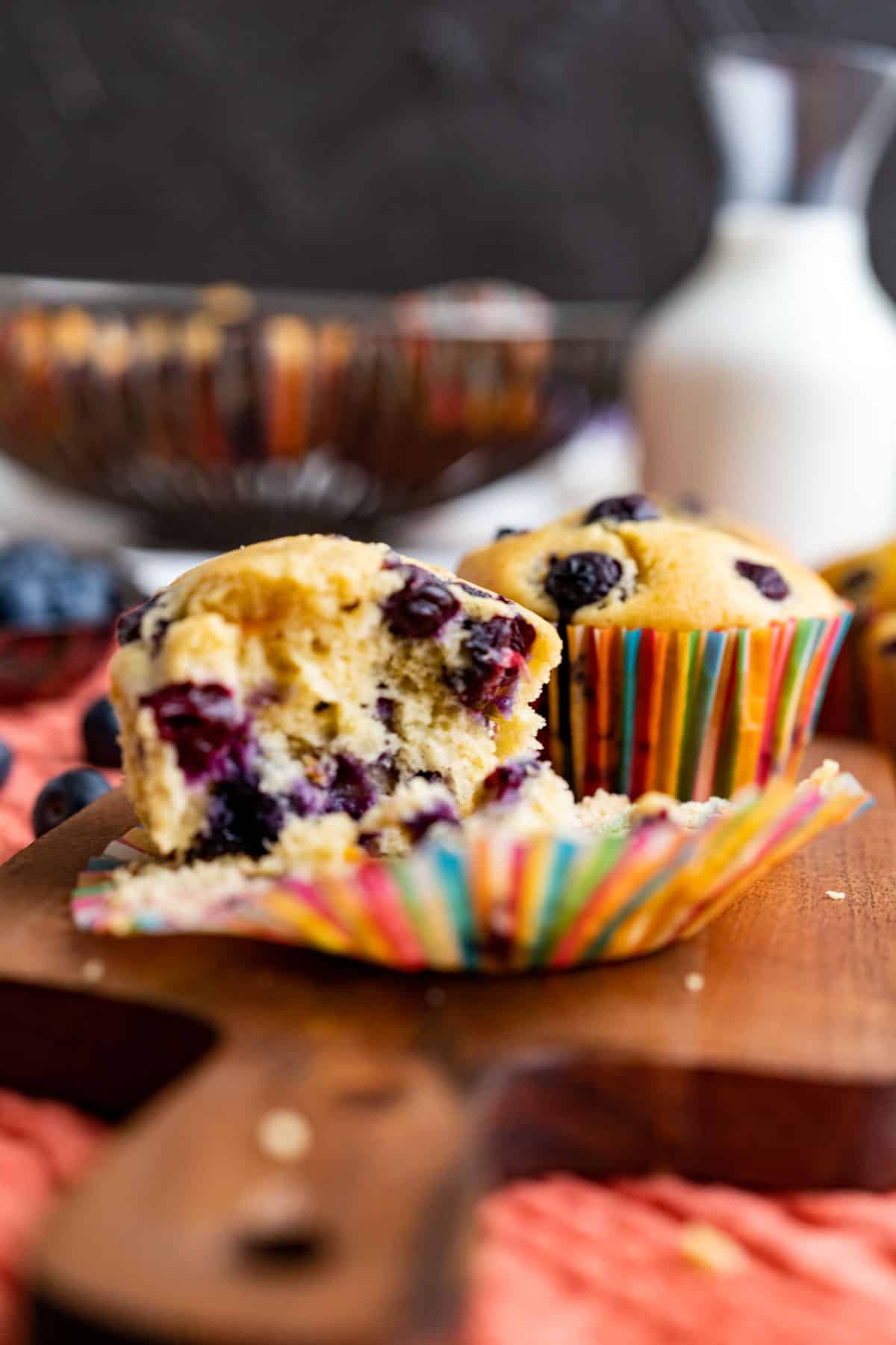 half opened old-fashioned blueberry muffins showing the texture and placed on the wooden plank.