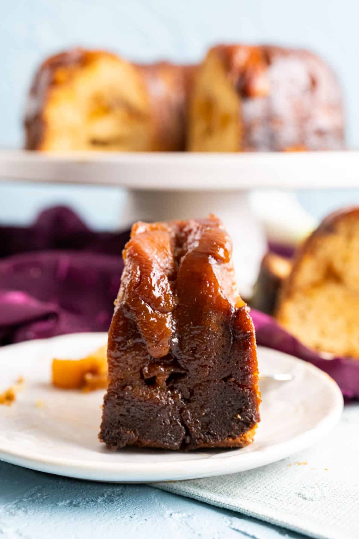 close shot of one slice of peach cobbler pound cake shown from the back in a small plate.