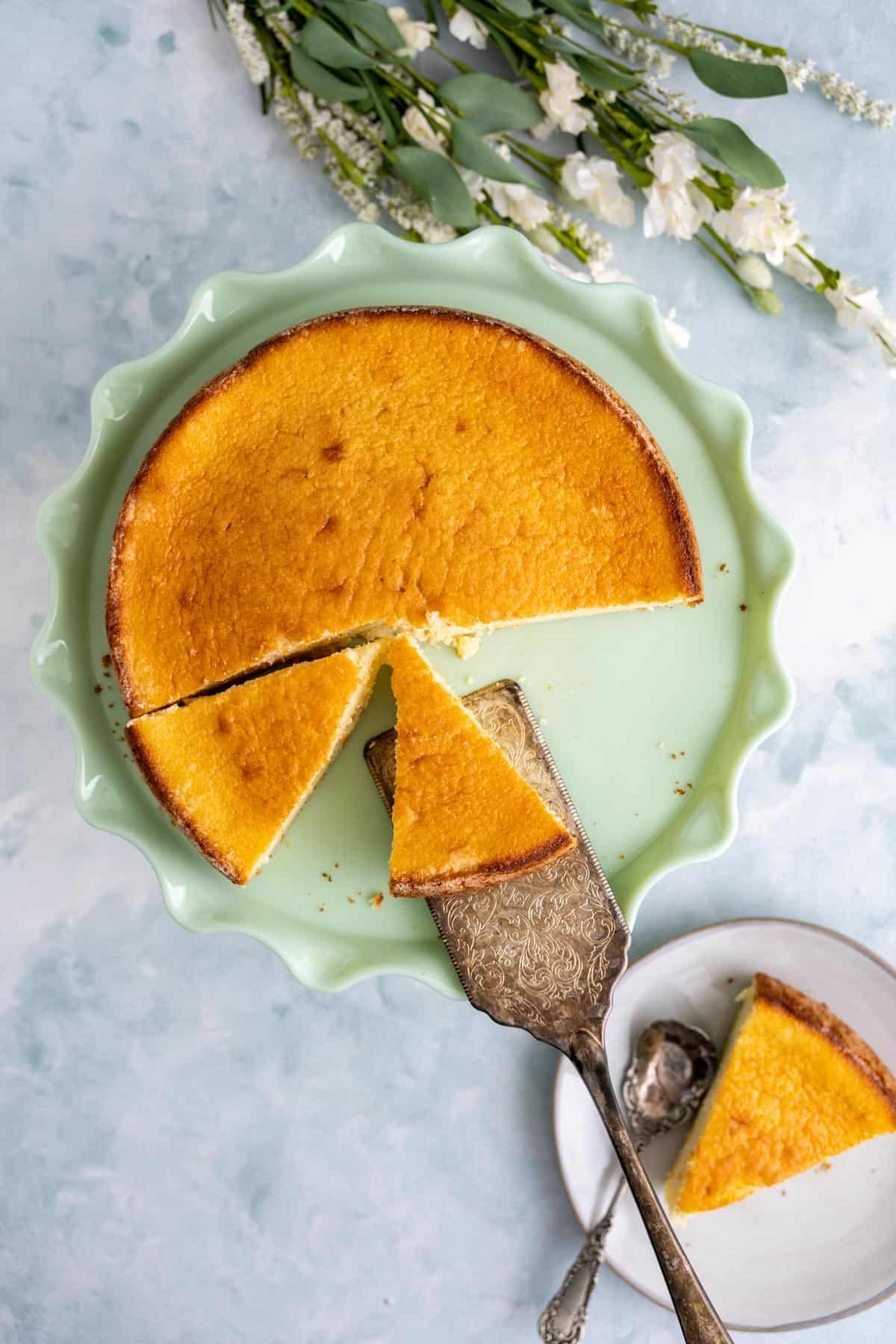 overhead shot of the california pizza kitchen butter cake in a green cake plate with a golden spoon.