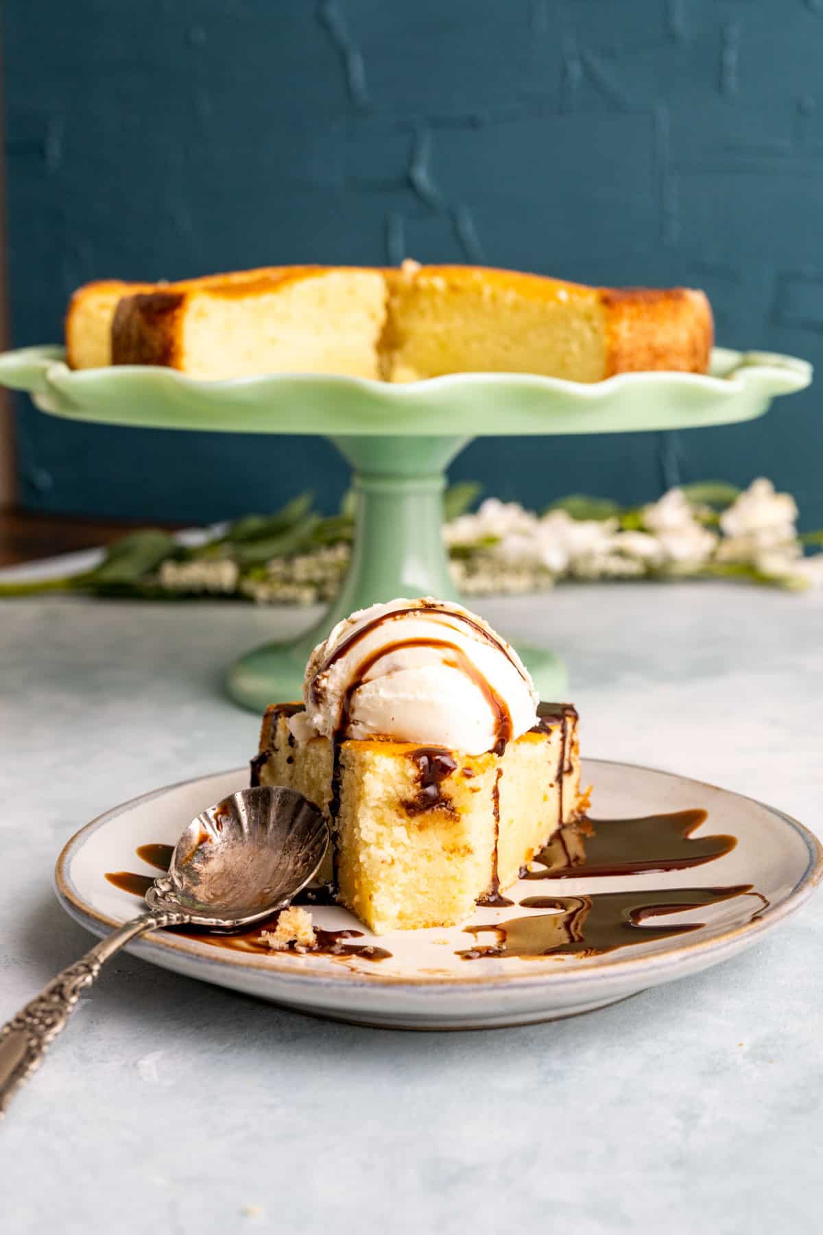 Close shot of the California Pizza Kitchen Butter Cake on a small white plate with a scoop of vanilla ice cream.