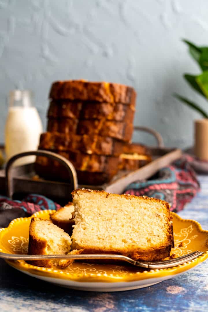 banana bread slice on a yellow plate with a fork.