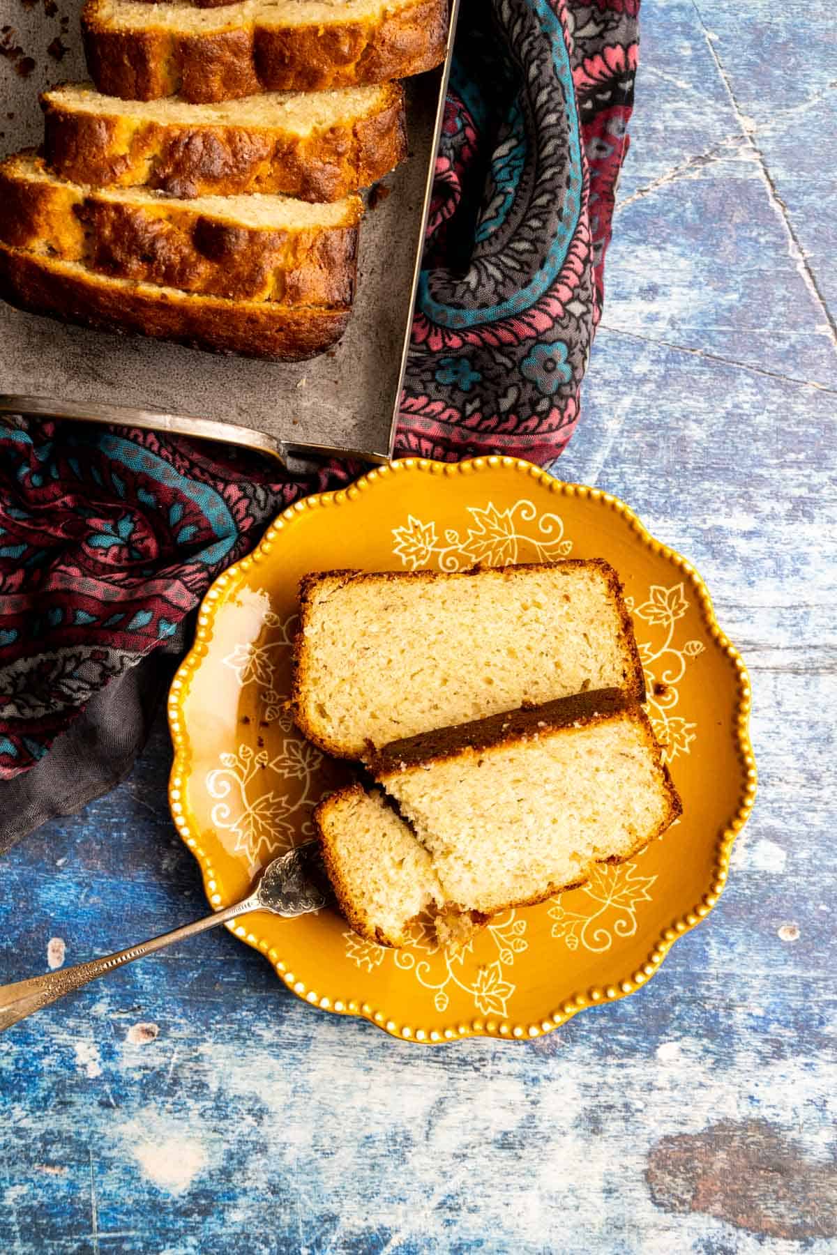 two 4-ingredient banana bread slices in a yellow plate on blue table.