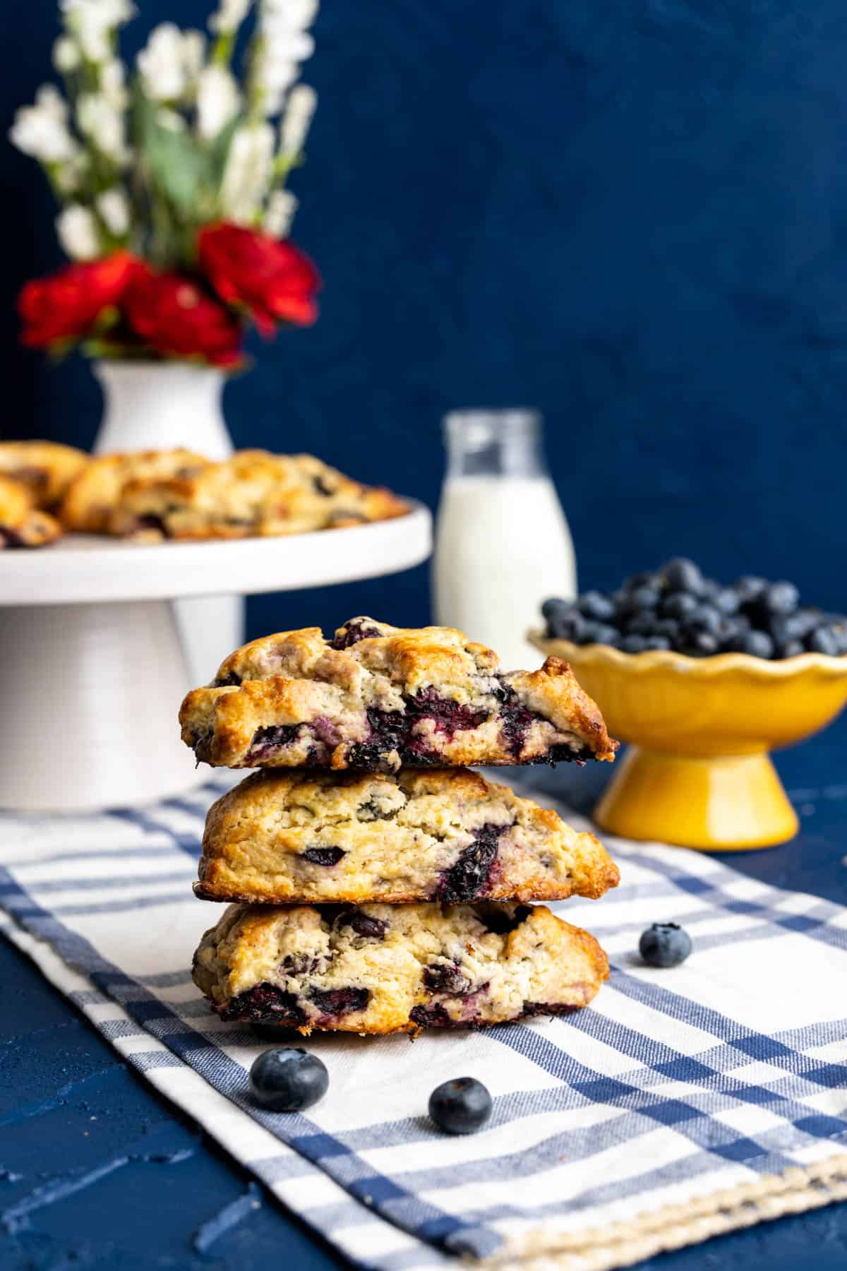 three starbucks blueberry scones on each other on blue table.