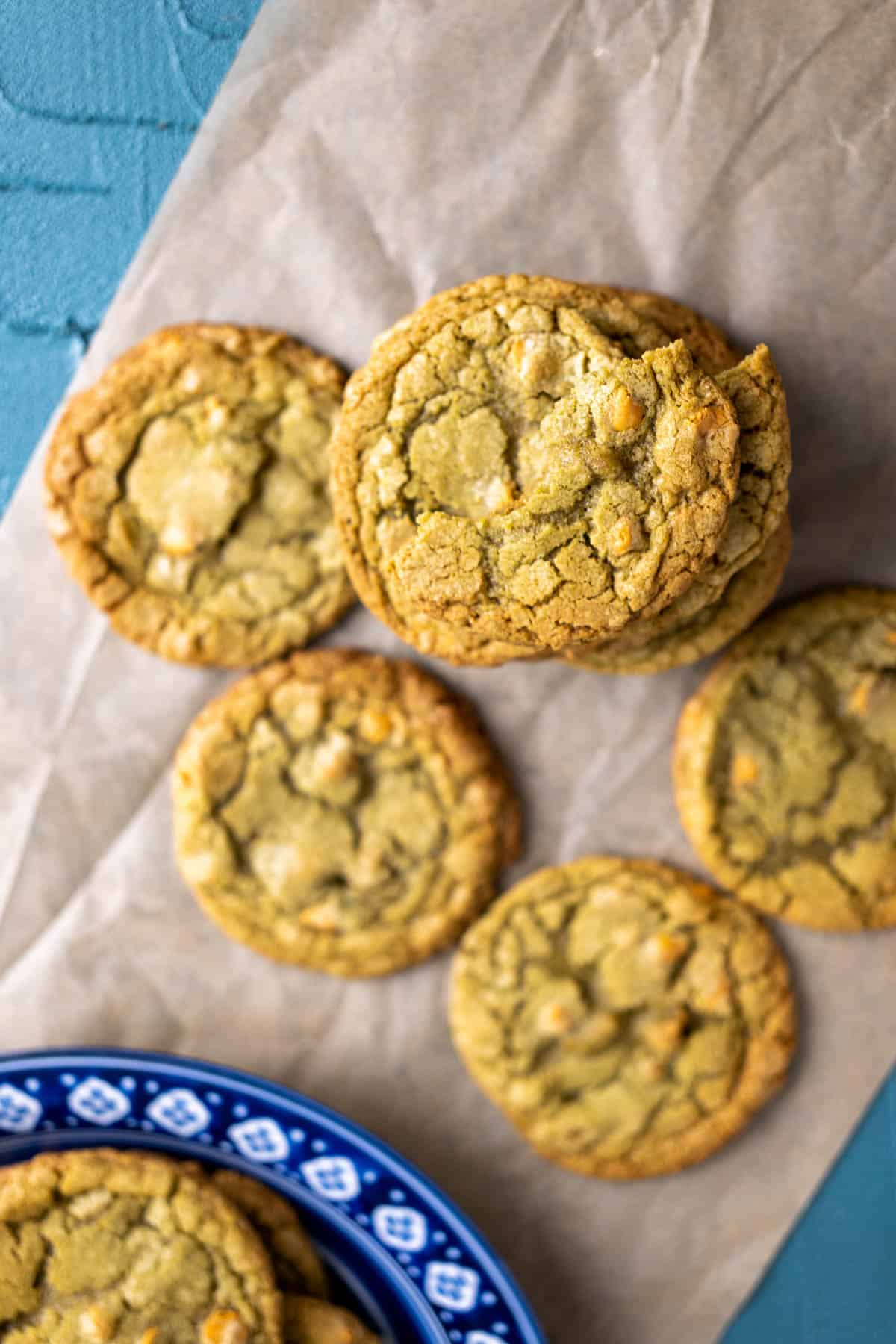 matcha cookies stacked on each other over brown paper.