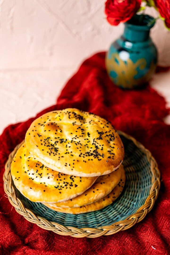 4 loaves of turkish bread on green plate.