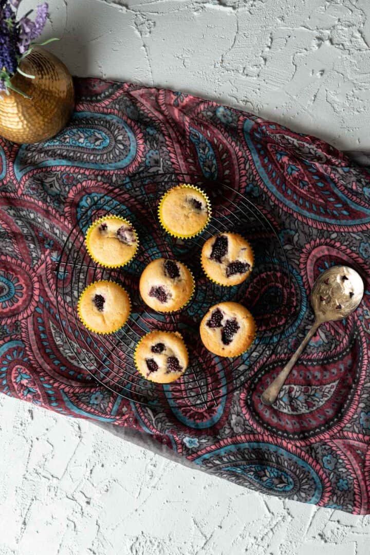 blackberry muffins on a round black tray.