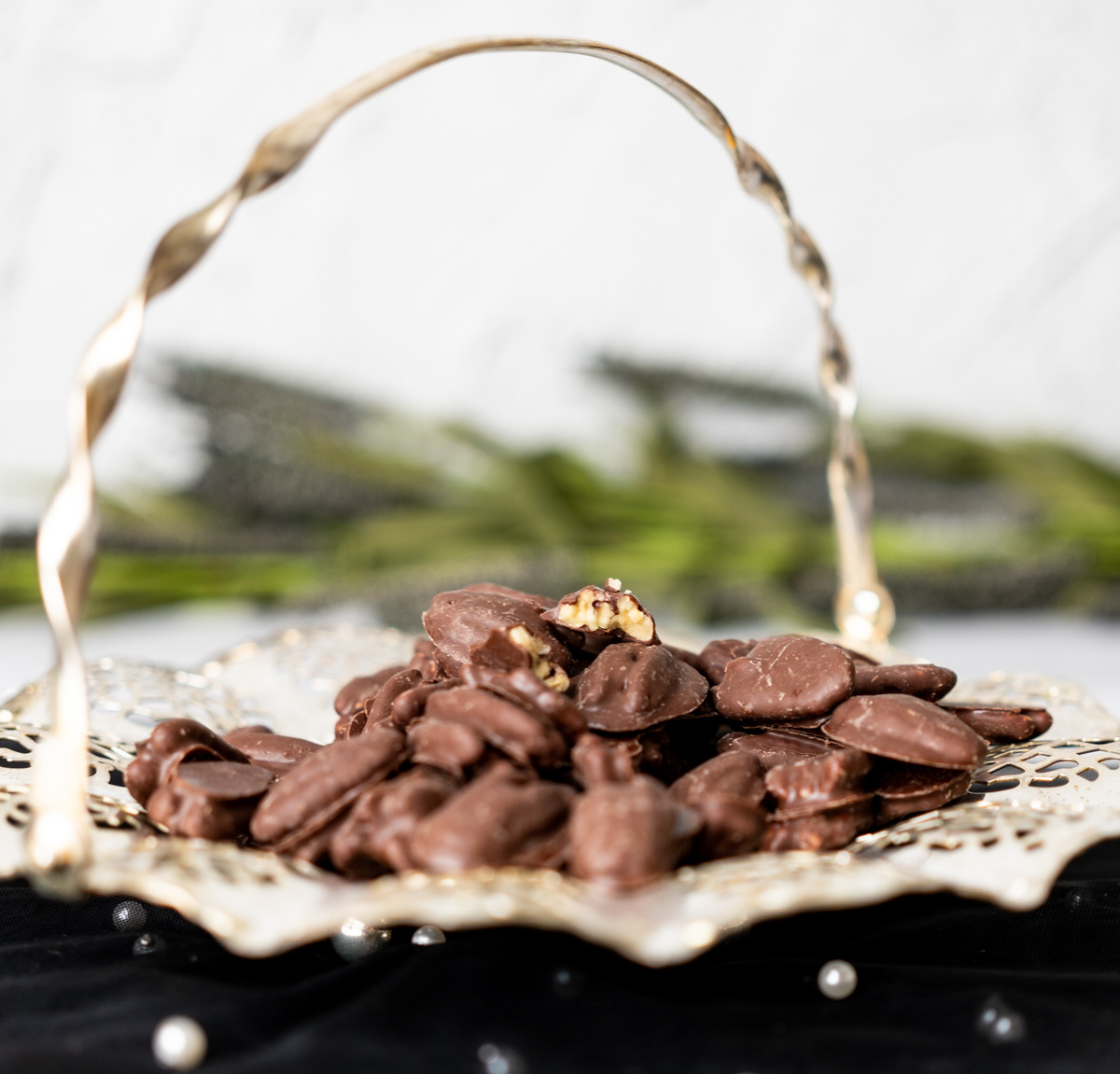 close up shot of the chocolate covered pecans cut in half showcasing the pecan inside chocolate.