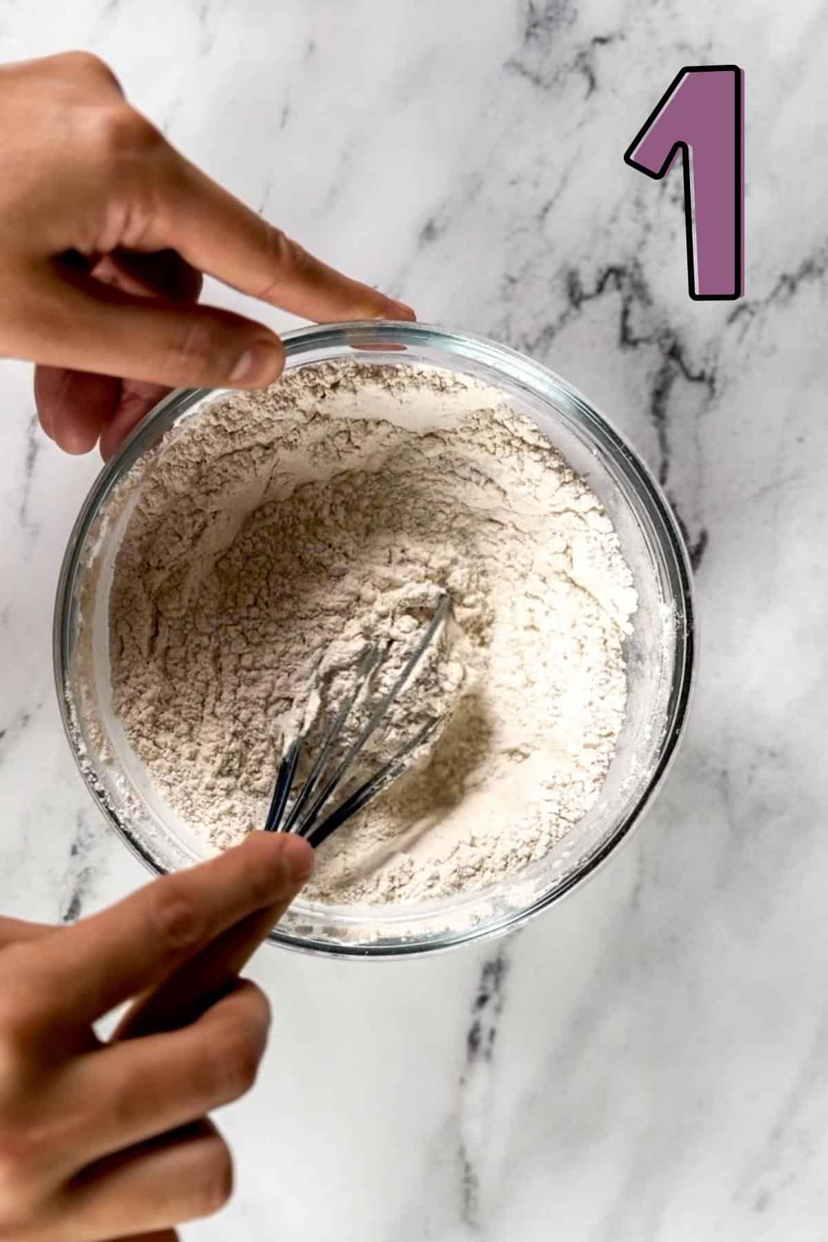 Whisking the dry ingredients for muffins in a bowl.