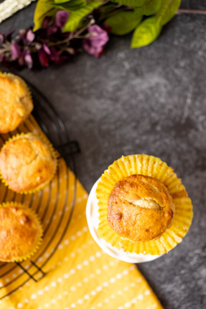 one bisquick banana muffin with flowers in the backdrop.