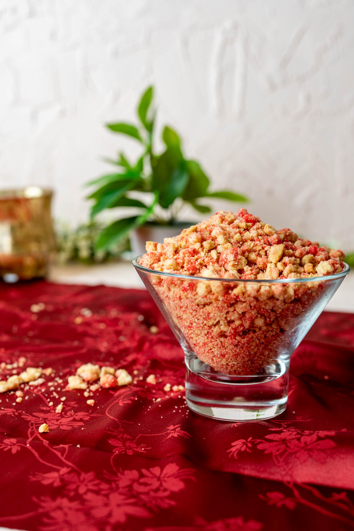 strawberry crunch topping in a transparent bowl placed on a red table cloth.