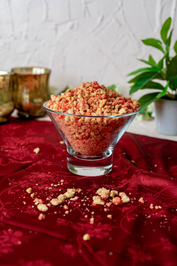 strawberry crunch topping in a transparent bowl on a red table cloth.