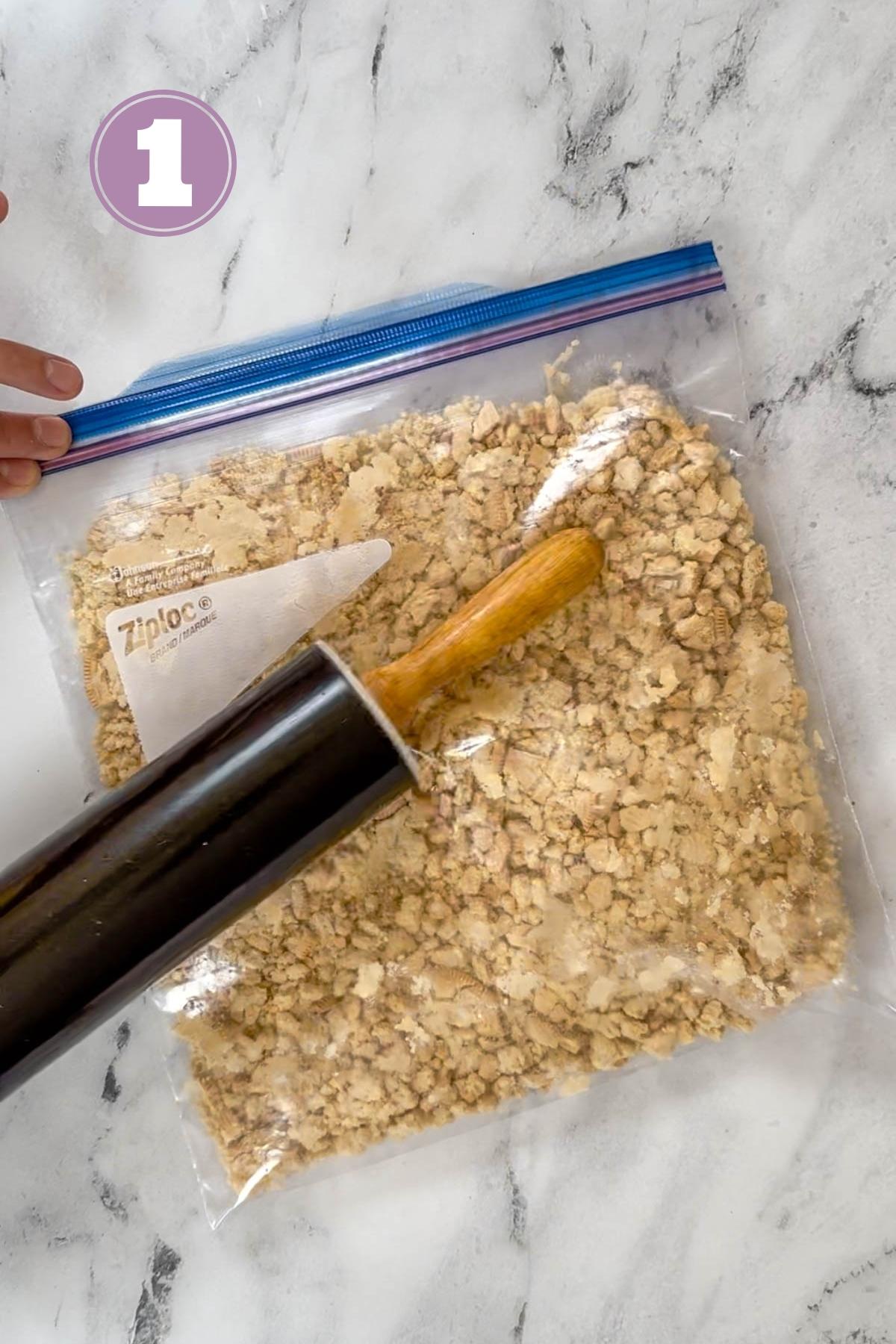 golden oreos in a plastic bag being pounded by a rolling pin.