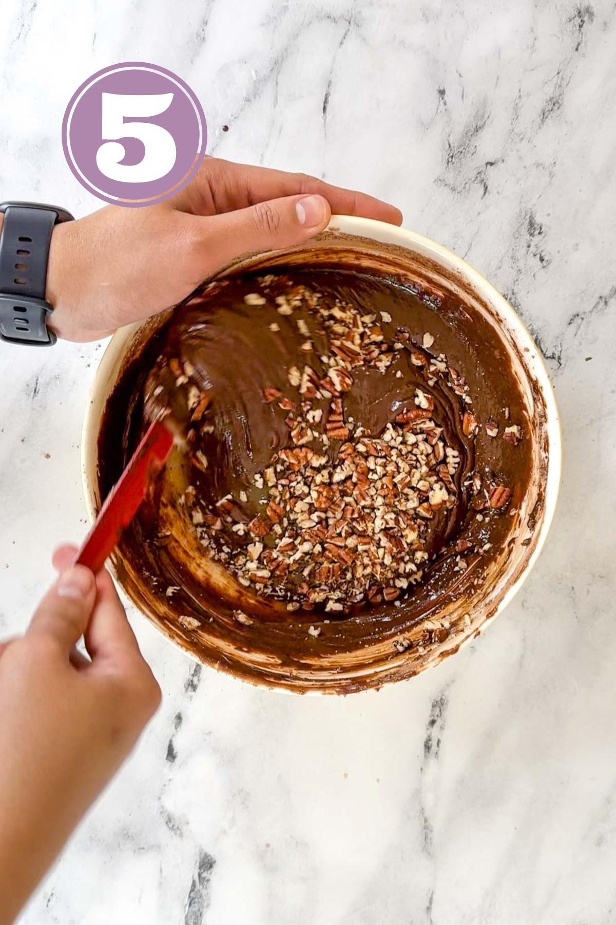 Folding in the chopped pecans in the brownies batter.