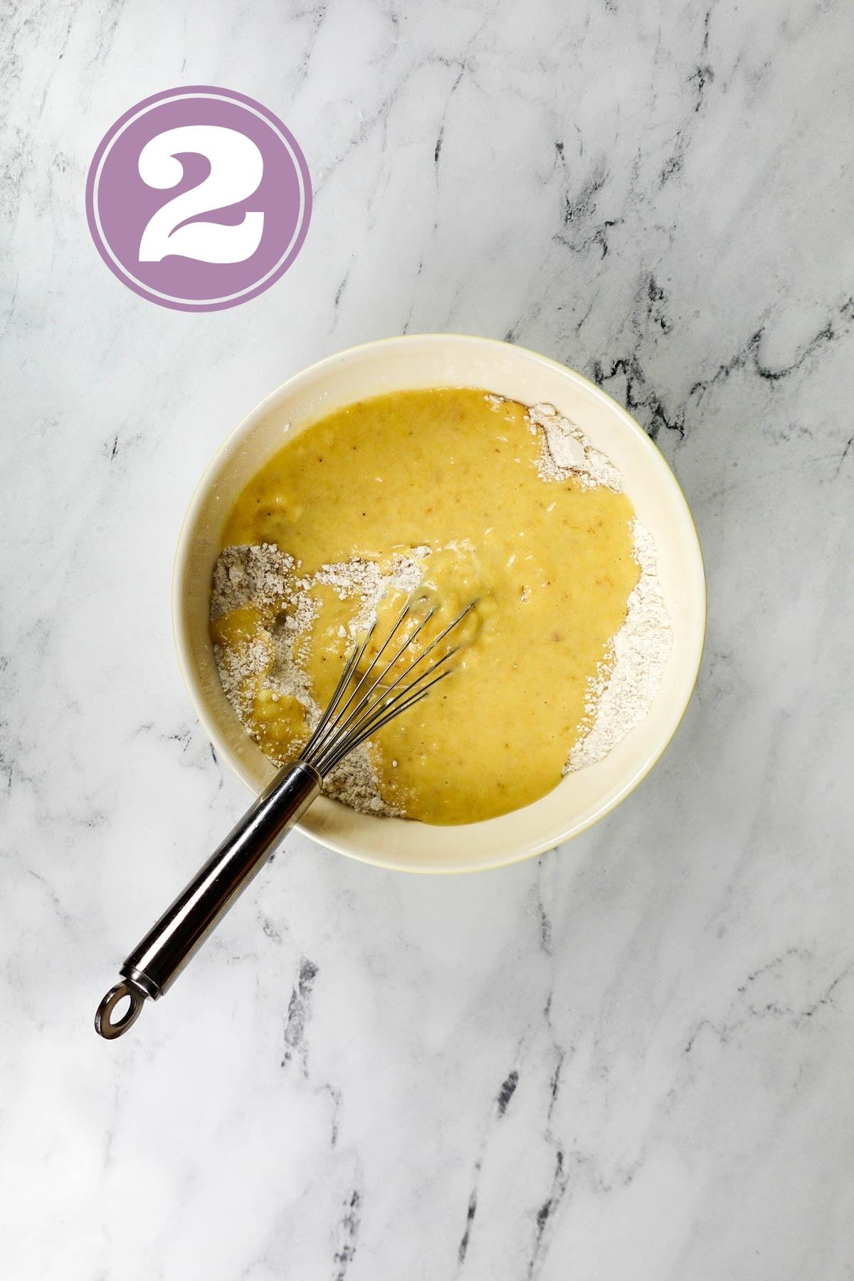 Mashed bananas and other wet ingredients in a bowl.