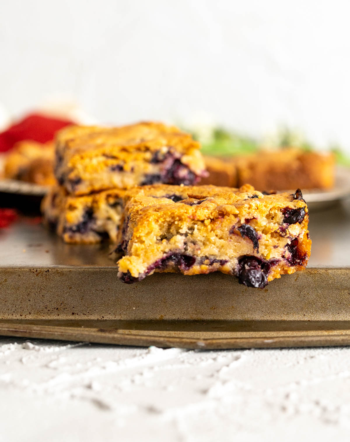 a close shot of one piece of a blondie showcasing oozing out blueberries.