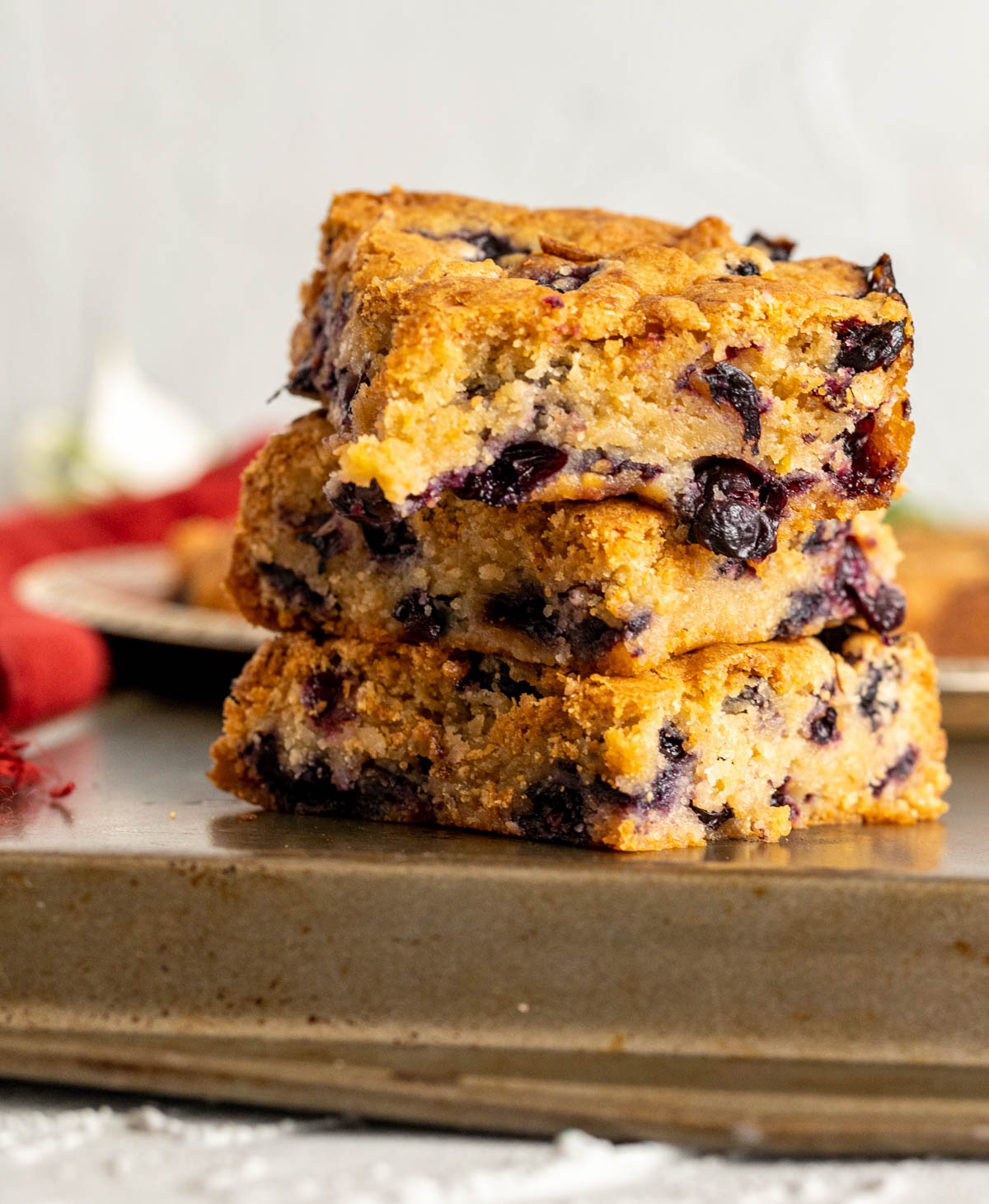 three blueberry blondies pieces sitting on each other on an old vintage tray.