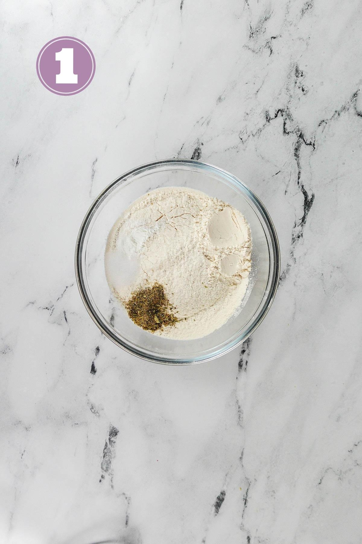 all purpose flour and other dry ingredients in a transparent medium sized bowl on the table.