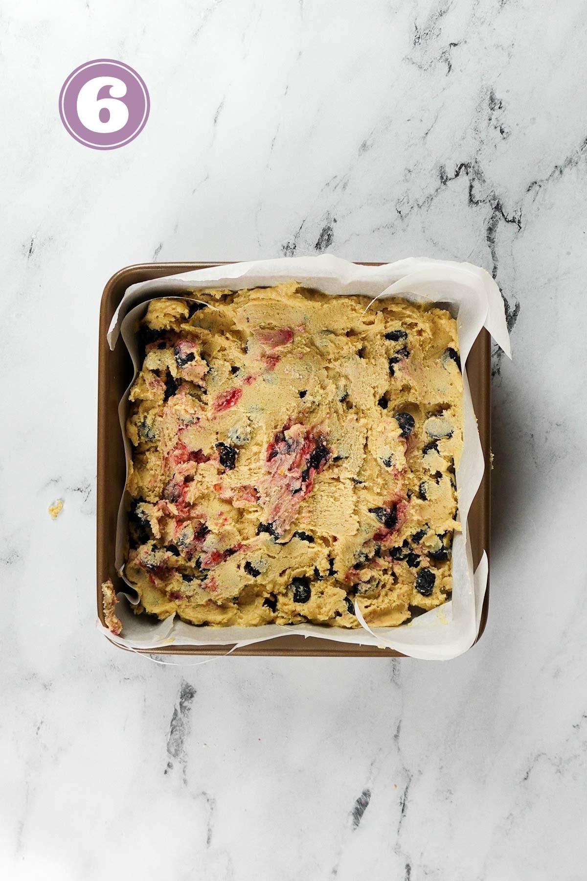 blueberry blondies batter in the 8-inch baking pan ready to be baked.