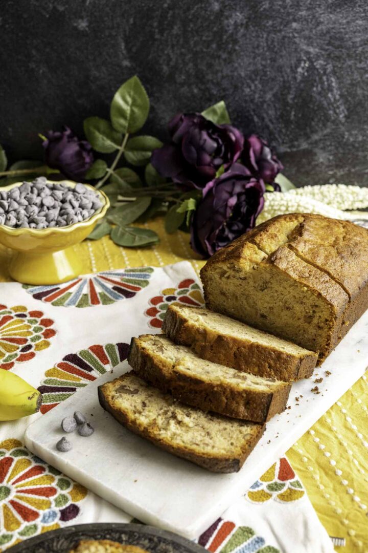 banana bread without baking soda placed on a marble slab on yellow table cloth.