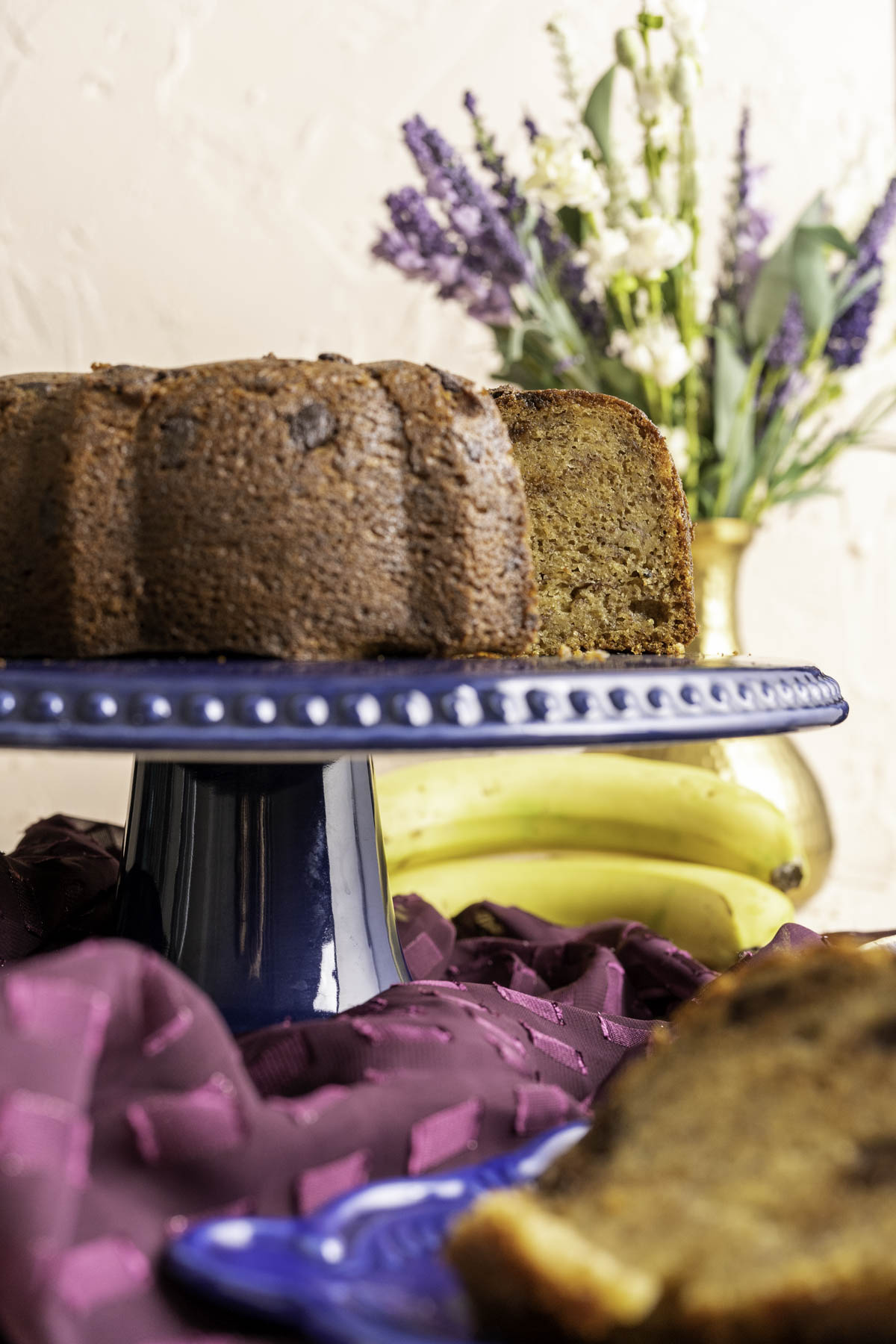 banana chocolate chip cake on blue decorative cake plate.