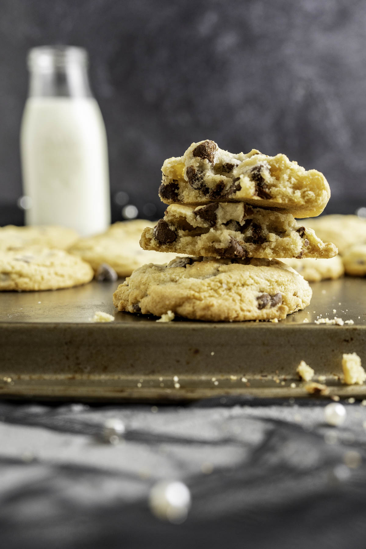 close up shot of chocolate chip cookie cut in half on an antique baking tray.