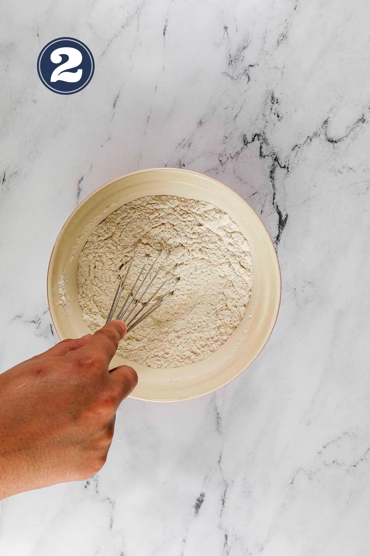 whisking dry ingredients in a mixing bowl.