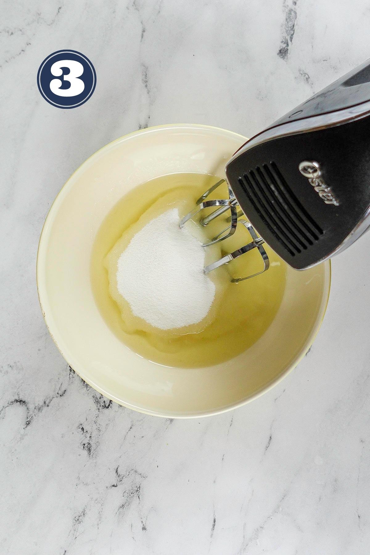 Beating eggs and sugar in a large bowl.