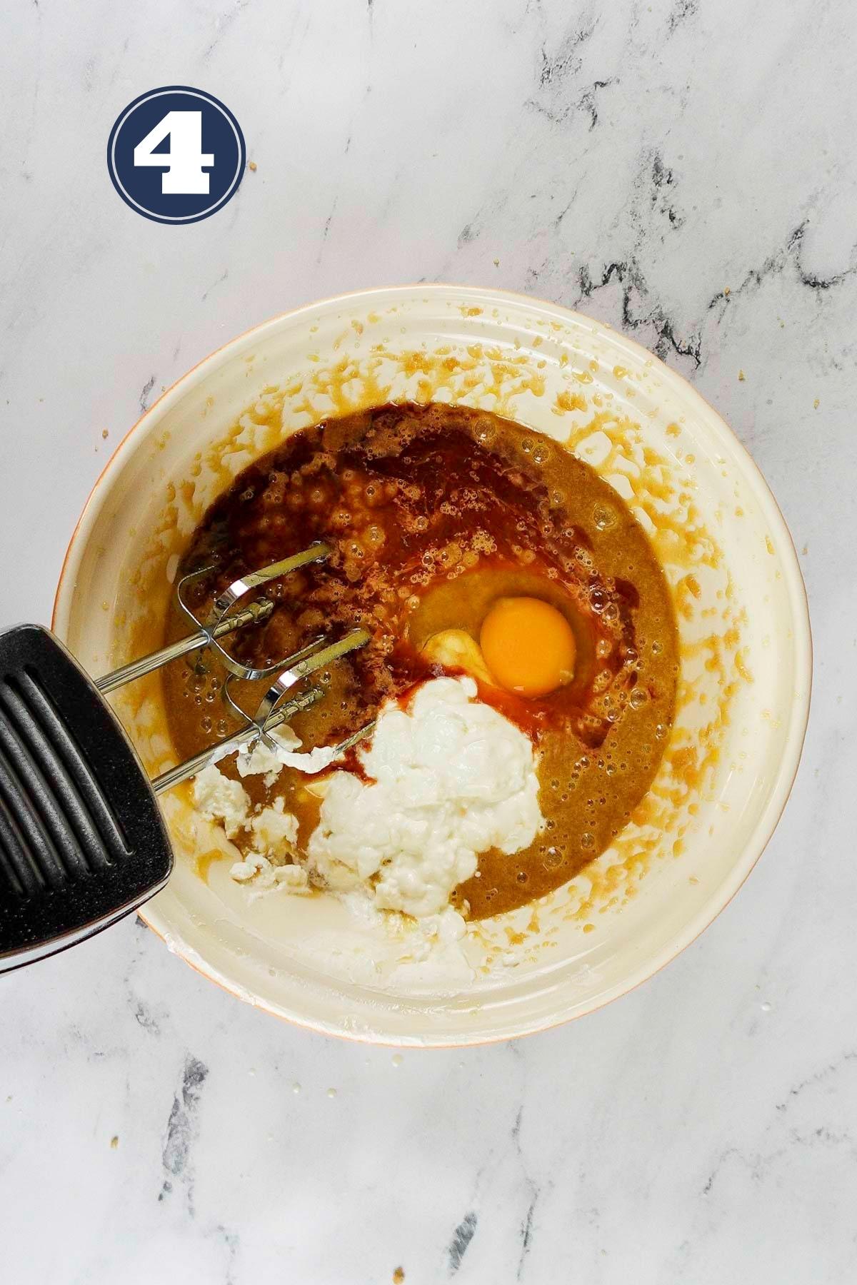 adding in the vanilla extract, sour cream and eggs into the cake batter.