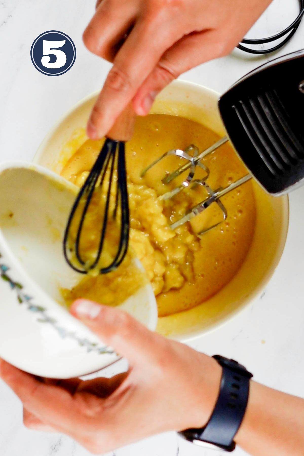 Adding mashed overripe bananas to the beaten eggs and sugar mixture.