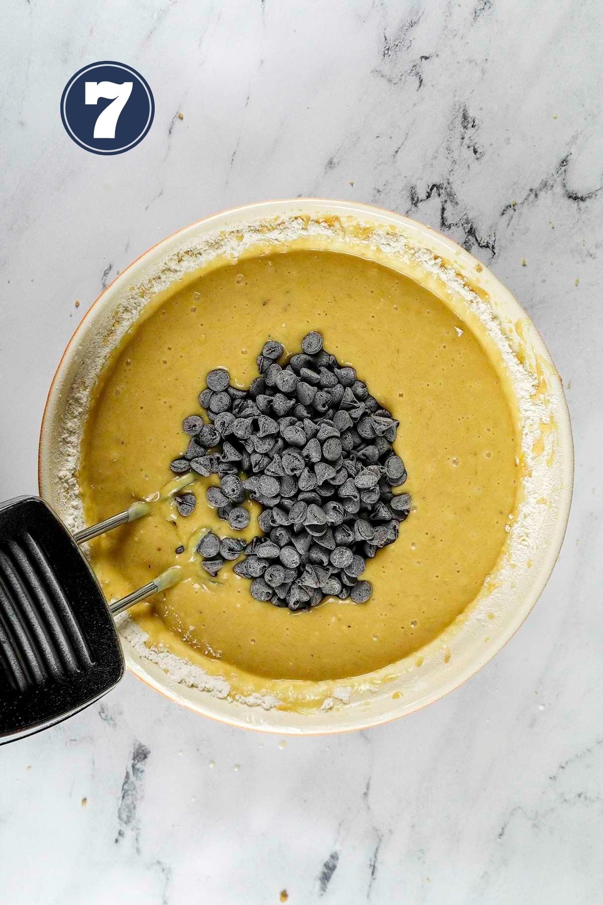 adding in the chocolate chips into the cake batter.