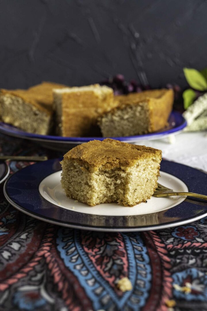 one piece of ghee cake in a plate with a golden fork.