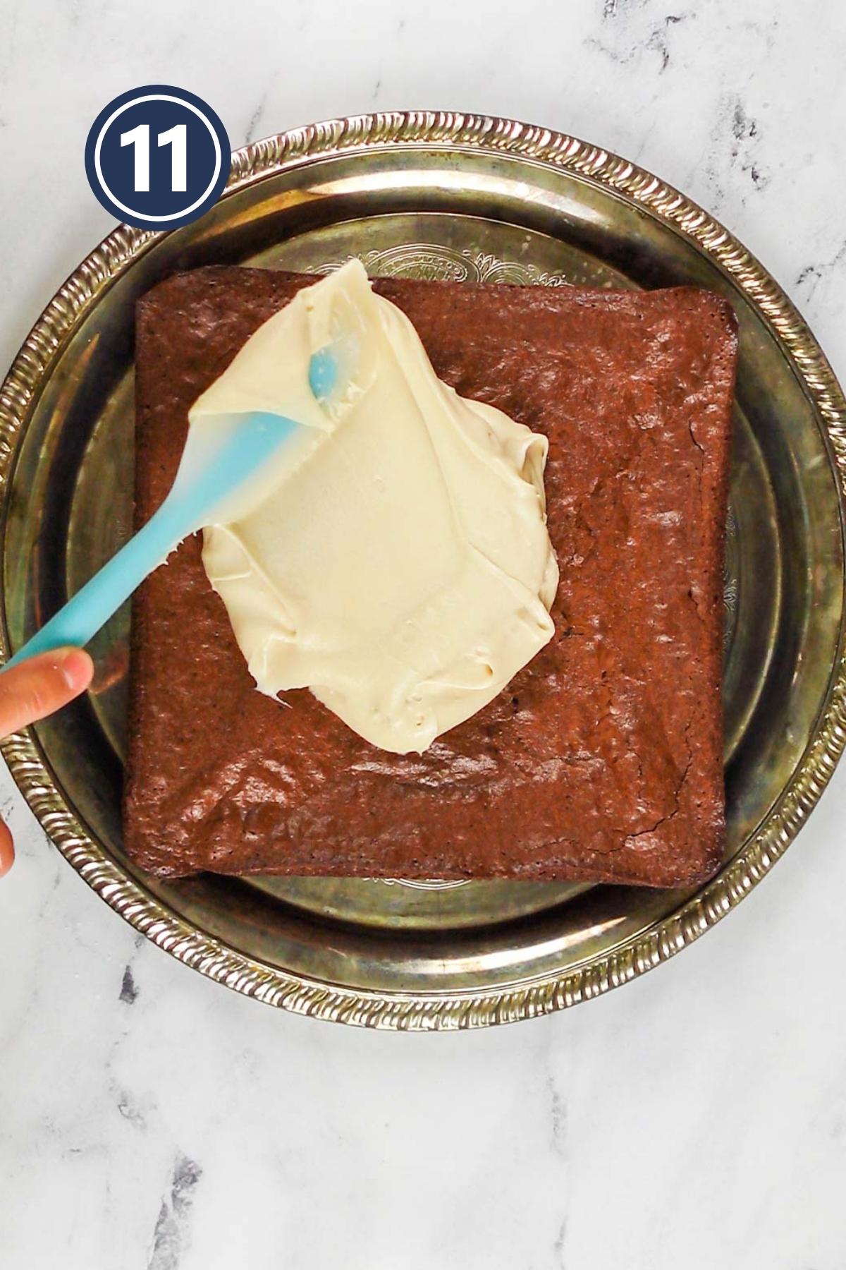 Spreading cream cheese frosting on the baked brownie.