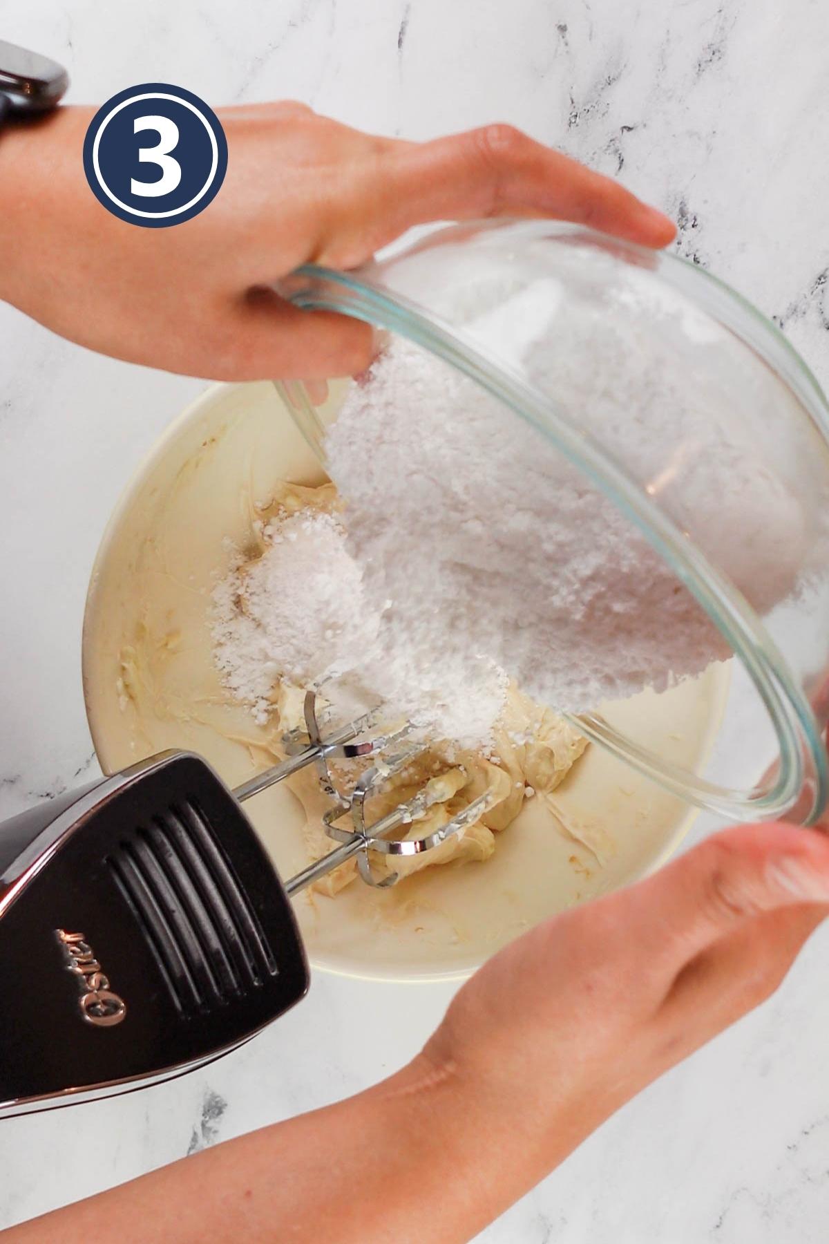 Adding in the powdered sugar in the beaten butter and cream cheese.