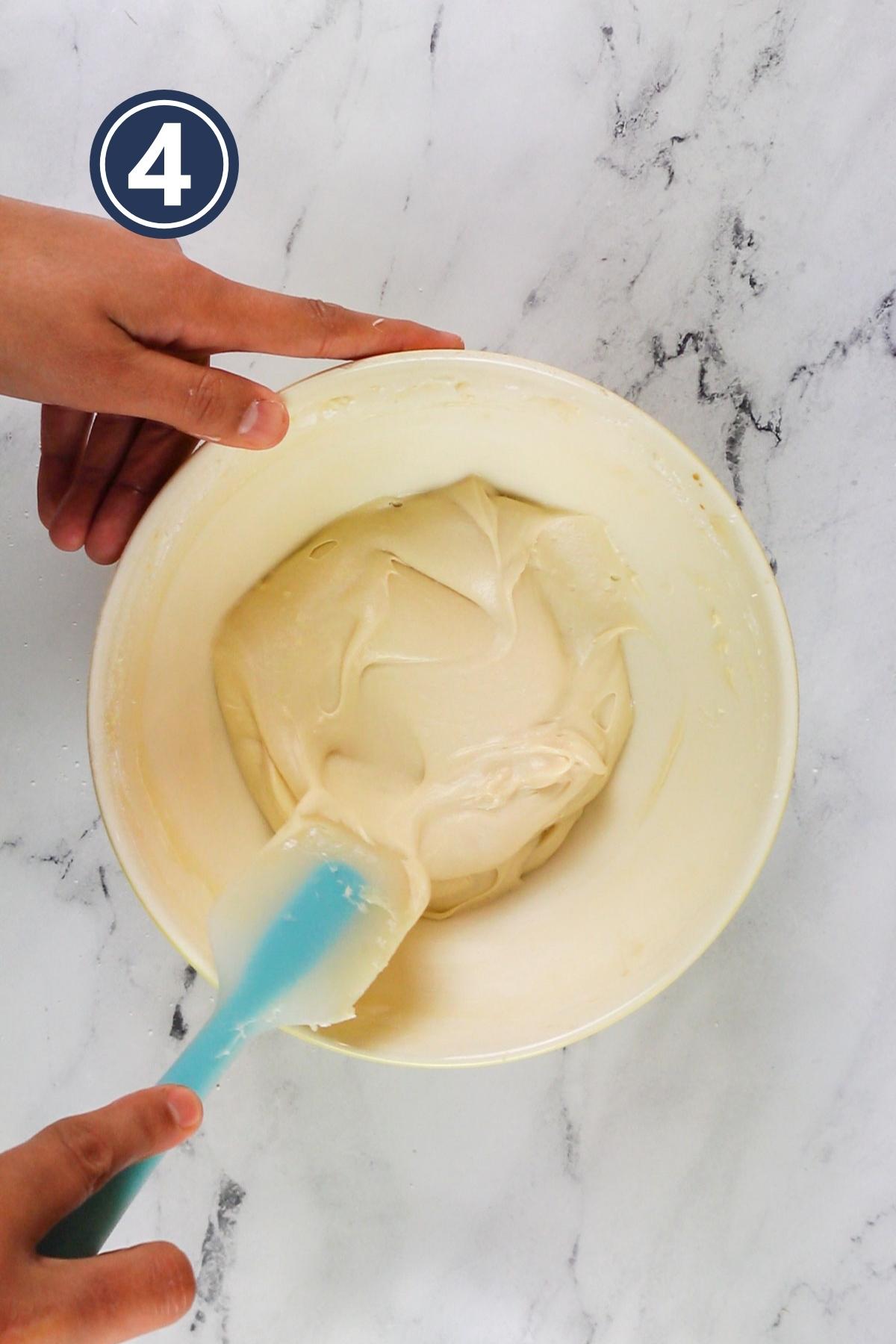 Prepared cream cheese frosting in the bowl.