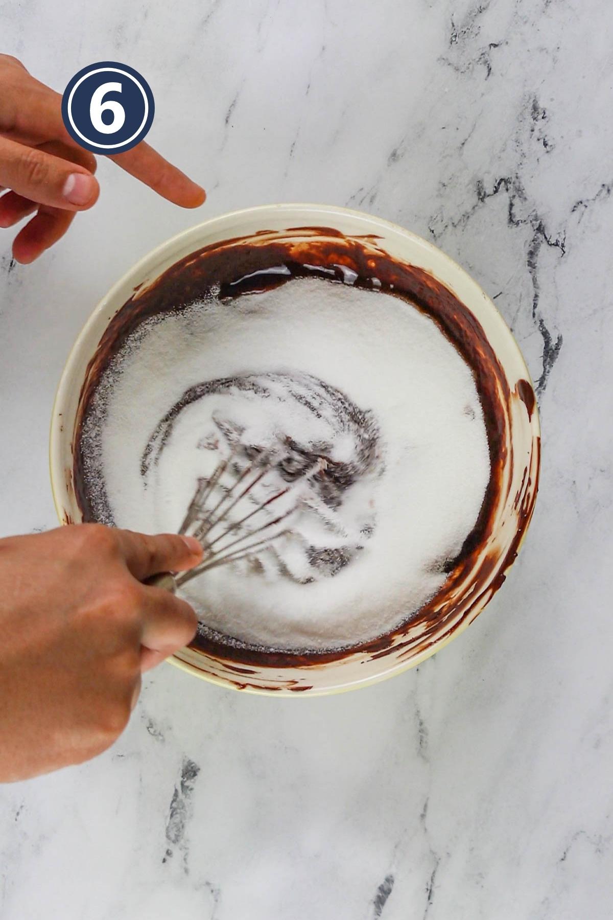 Mixing castor sugar in the brownie batter.