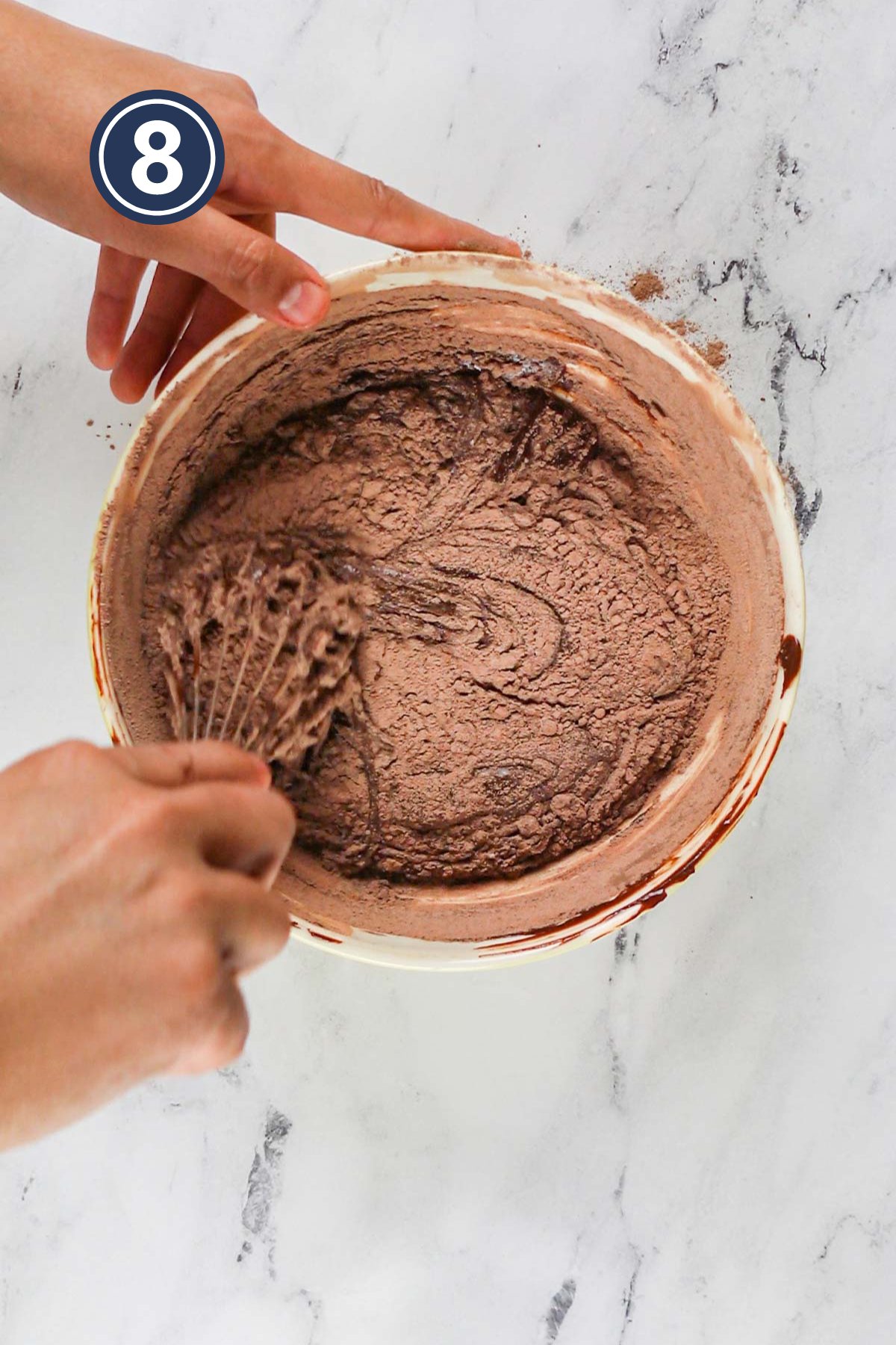 Mixing the dry ingredients with wet ingredients of the brownie batter.